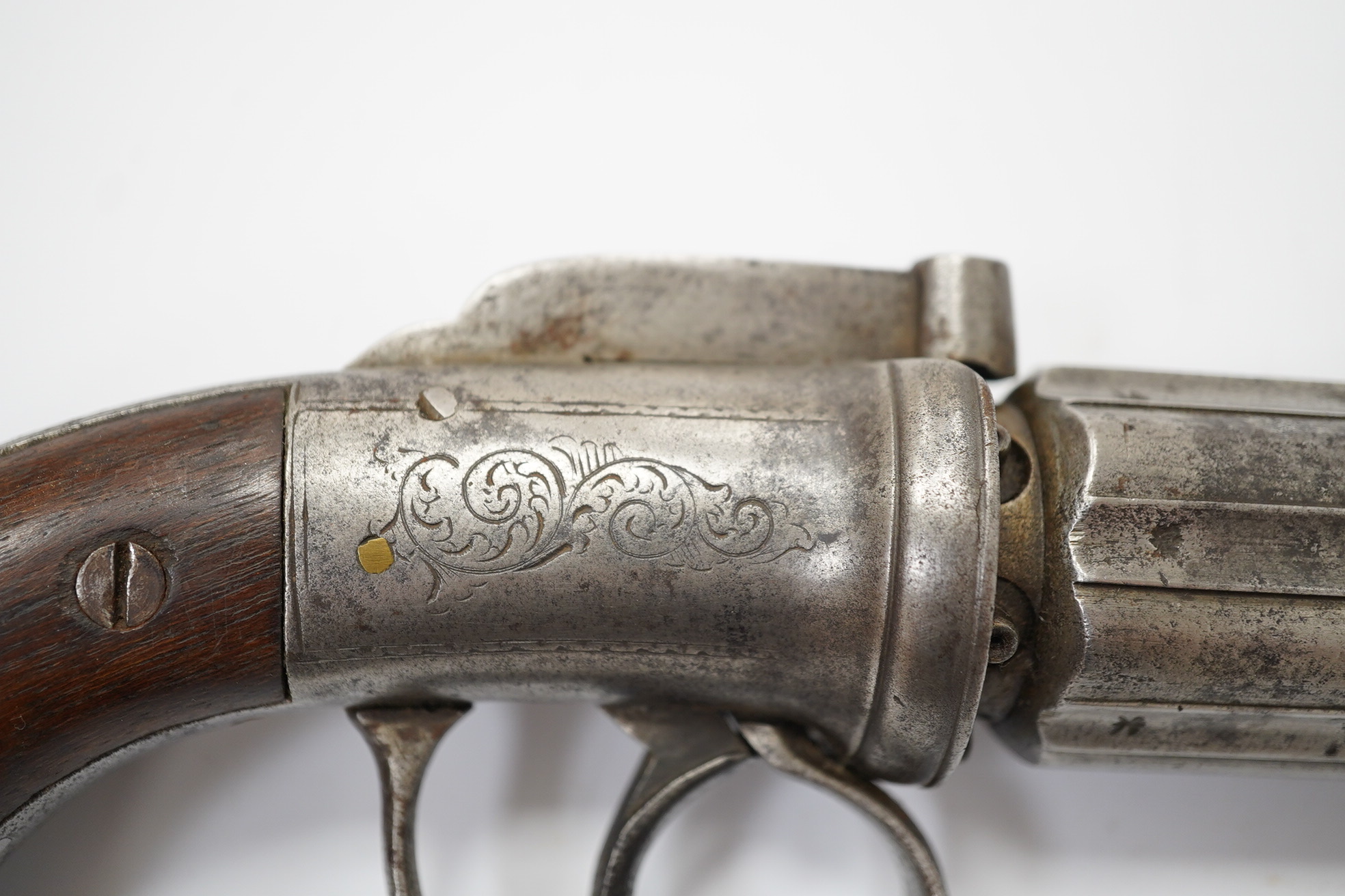 A six shot self-cocking percussion pepper box revolver, with fluted barrels, Birmingham proofed, round frame, and scroll engraved wooden grips, barrel 6.5cm. Condition - fair, alterations to the frame and grip.